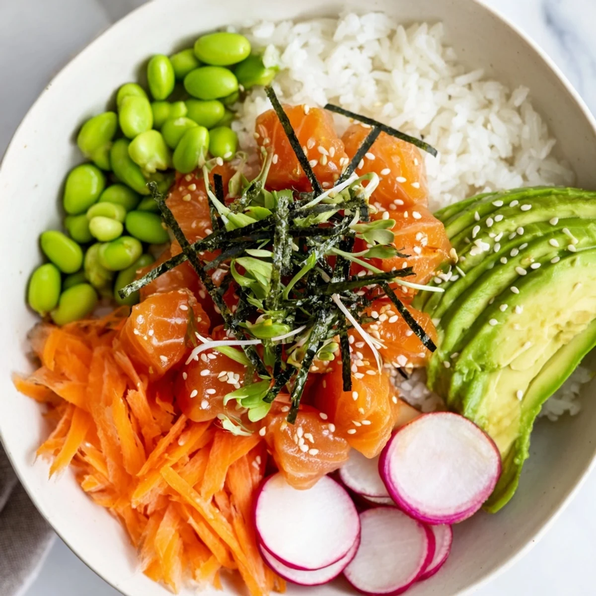 A delicious poke bowl: marinated fish atop fluffy rice, garnished with vibrant toppings and sesame seeds.
