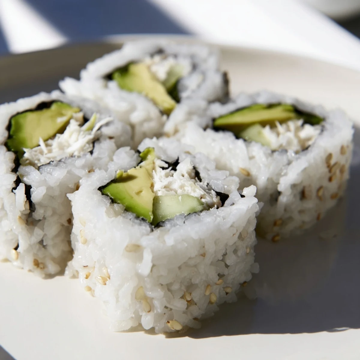 Steaming-hot California Roll, artfully sliced and ready to dip in soy sauce with wasabi.