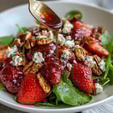 Spring Dinner Party Strawberry Arugula Salad with Balsamic Glaze, a vibrant mix of sweet strawberries, peppery arugula, and creamy goat cheese, drizzled with tangy balsamic reduction.