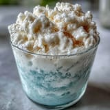 Two servings of TikTok Cloud Slushie, a light and bubbly lemon-lime slushie topped with sweetened condensed milk swirls.