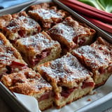 Tangy rhubarb layered with creamy custard atop a perfect shortbread crust, a sweet treat.