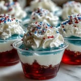 Festive 4th of July Firecracker Jello Shots showing red, white, and blue layers.