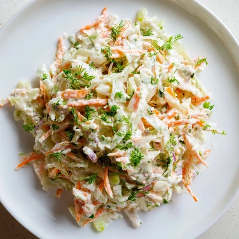 Crisp coleslaw with apple, boasting shredded cabbage, sweet apple, and creamy dressing, perfect for a picnic.
