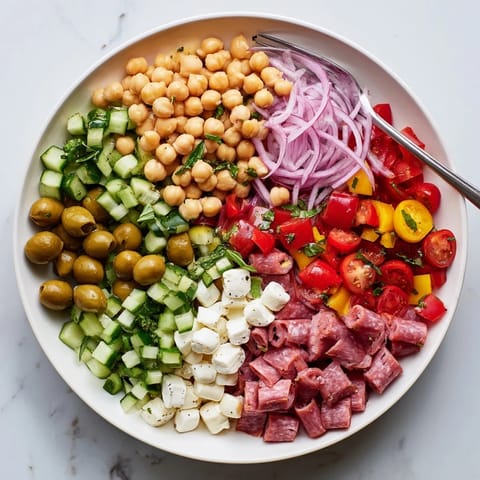 Hearty Crunchy Antipasto Chopped Salad served in a rustic bowl with colorful veggies and fresh herbs.