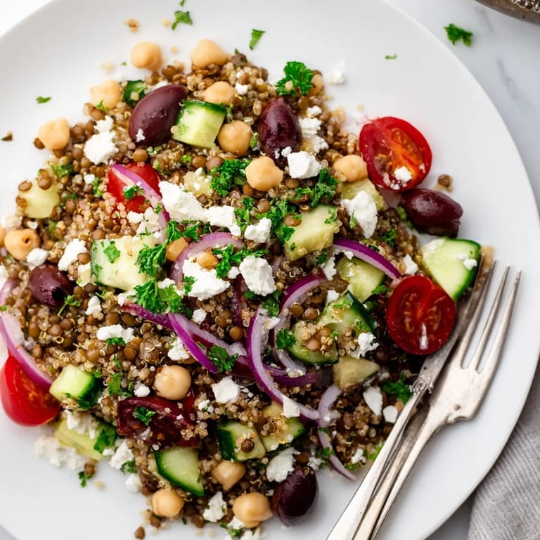 Close-up Greek Power Salad with feta crumbles, Kalamata olives, and colorful cherry tomatoes on a rustic wooden table, perfect for lunch.