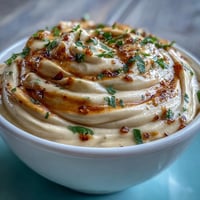 Creamy chipotle lime mayonnaise with smoky peppers, fresh lime zest, and tangy Dijon mustard in a glass bowl.
